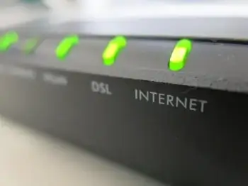 A black modem displayed on a desk with green lights