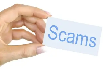 A woman holding a sign reading "Scams"